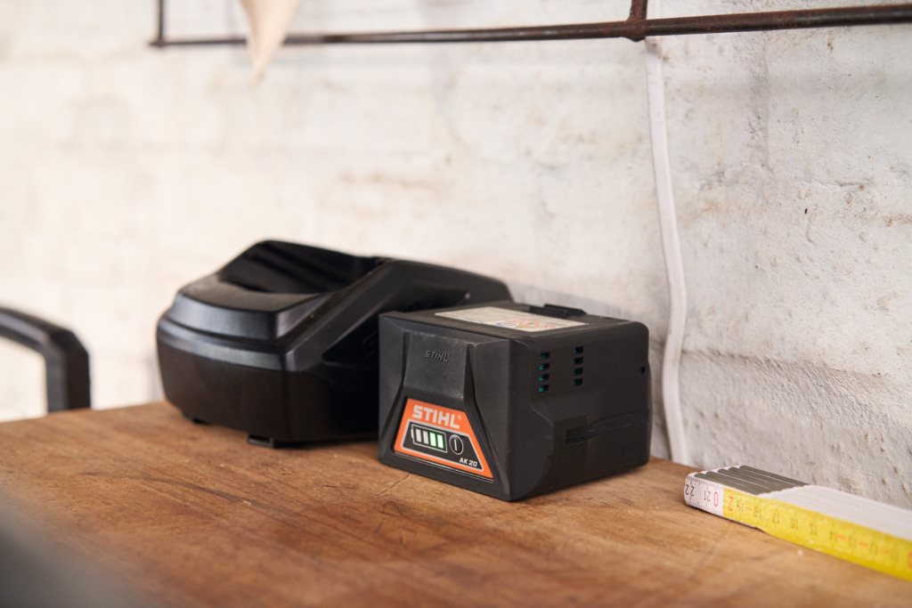 STIHL battery and battery charger on top of a workbench